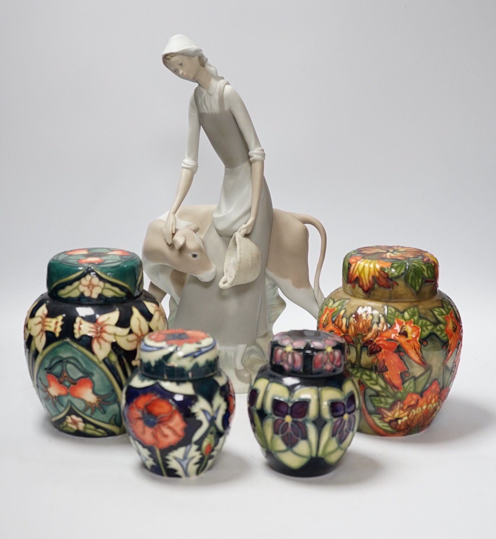 Four modern Moorcroft jars and covers, largest 16cm high, three boxed and a Nao figure group, tallest 95cm high